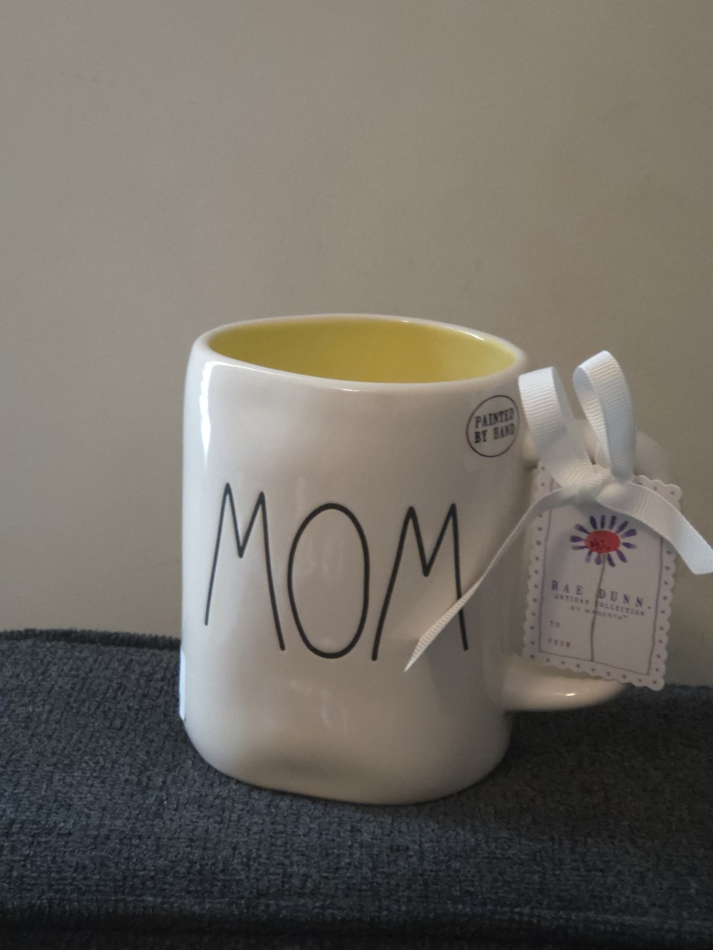 Rae Dunn MOM Coffee Mug with Yellow Interior And Double Sided Flower Detail.